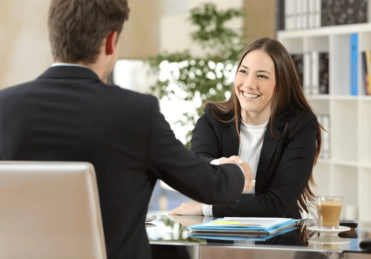 Recruitment solutions - A man and woman shaking hands in an office.